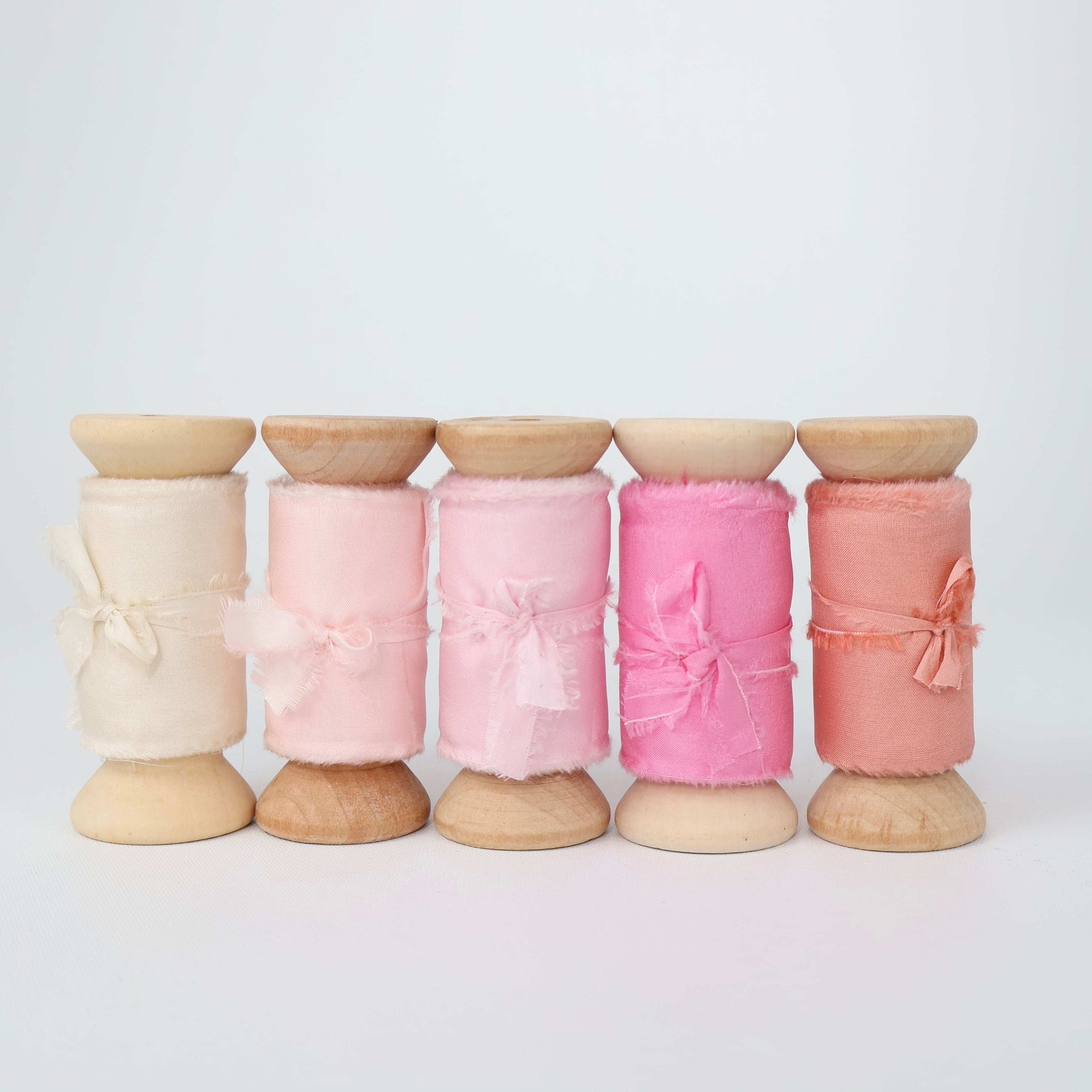 Five wooden spools of Habotai Silk Ribbon  ranging in ivory, pinks and peach colours for handtied wedding bouquets and wedding stationary