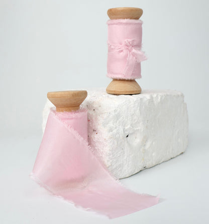 Two spools of baby pink 100% Habotai silk ribbon.